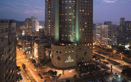 A high-rise hotel with a modern glass facade, multiple floors, and a prominent entrance at the base.