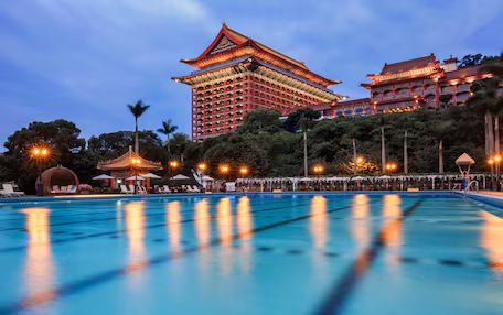 A swimming pool with a traditional building in the background.