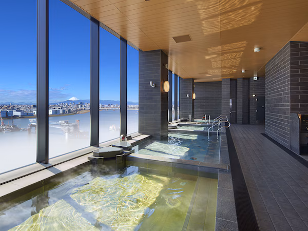 A modern indoor swimming pool with clear views of a cityscape and a mountain.