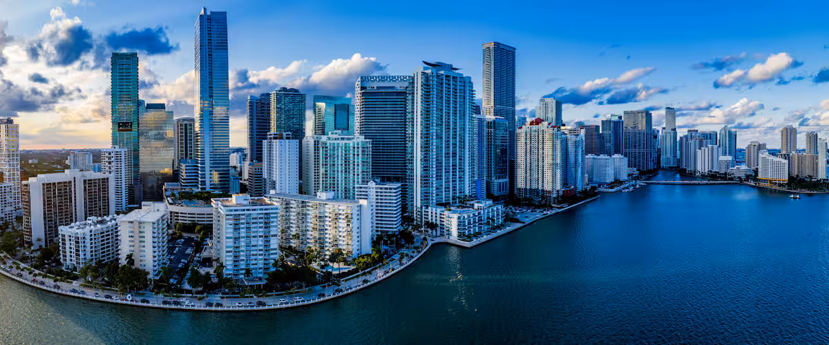 A coastal cityscape with high-rise buildings and a marina.